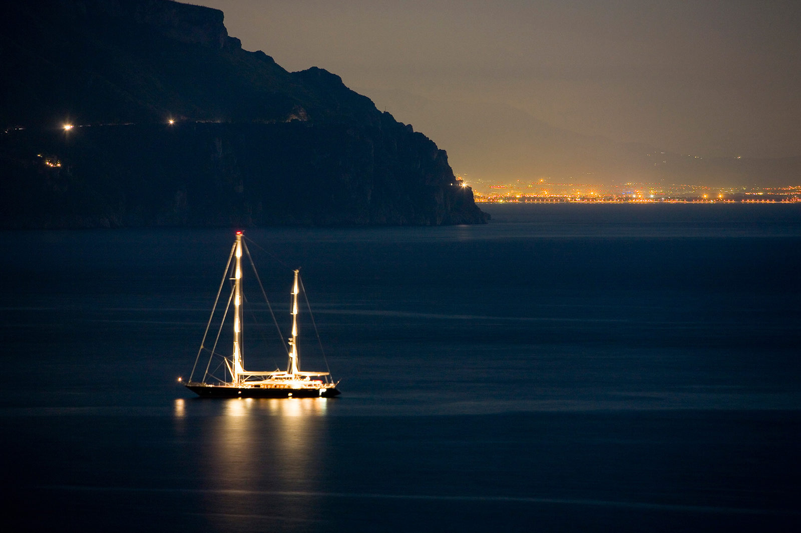 Illuminated sailing yacht at anchor at night